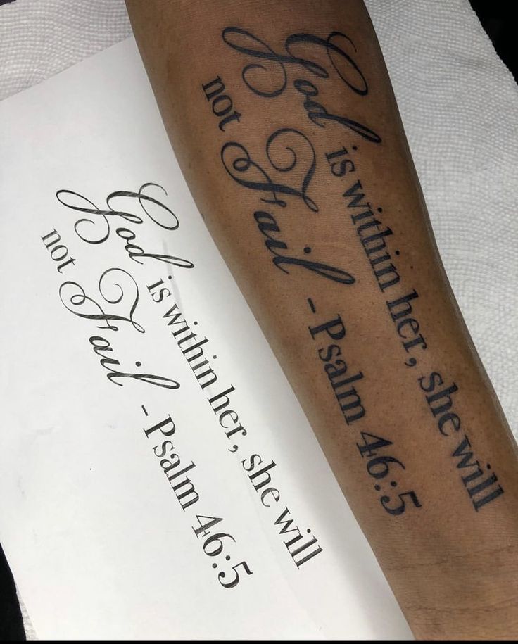 a person with a tattoo on their arm next to a piece of paper that has writing on it