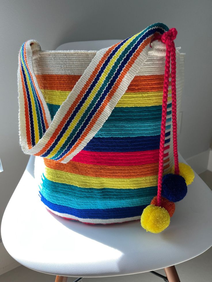 a multicolored bag sitting on top of a white chair