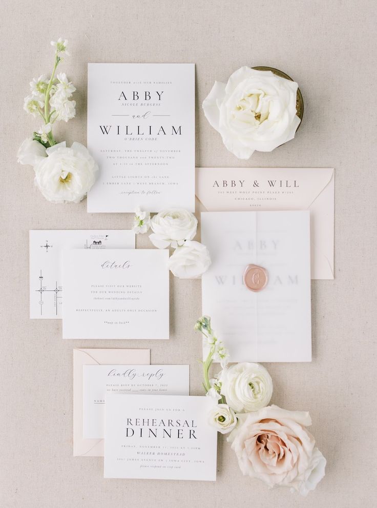 the wedding stationery is laid out with flowers