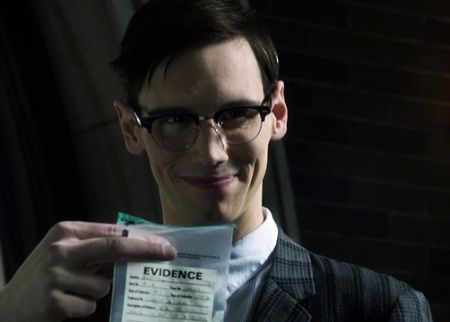 a man in glasses holding up a piece of paper