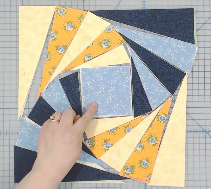 someone is cutting out the squares on top of each other to make an origami quilt