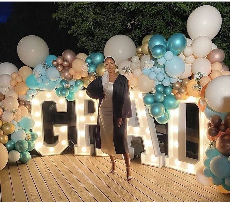 a woman is standing in front of balloons and letters that spell out the word chaos