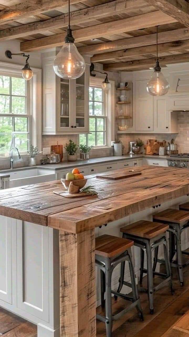 a large kitchen island with stools in the center and lights hanging from the ceiling