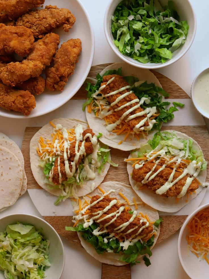 chicken tacos and lettuce on tortillas with ranch dressing in bowls