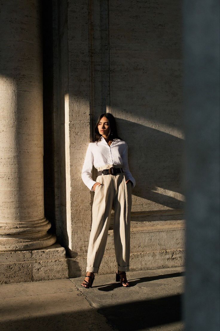 a woman is standing in front of some pillars