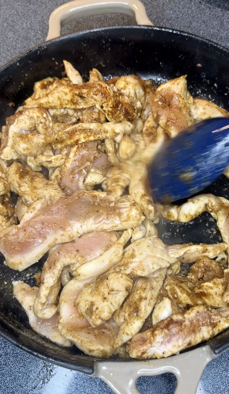 a pan filled with meat cooking on top of a stove