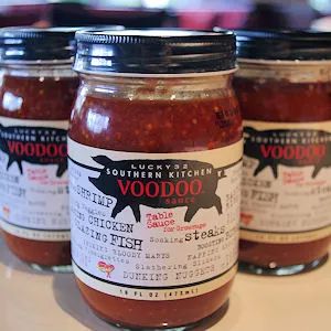 three jars of red sauce sitting on top of a counter