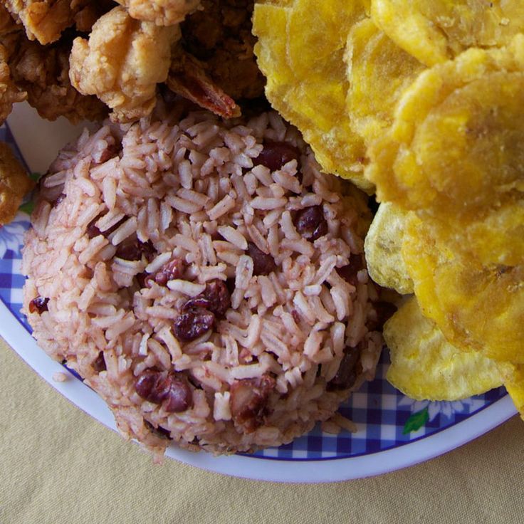 a plate with rice, beans and fried food on it