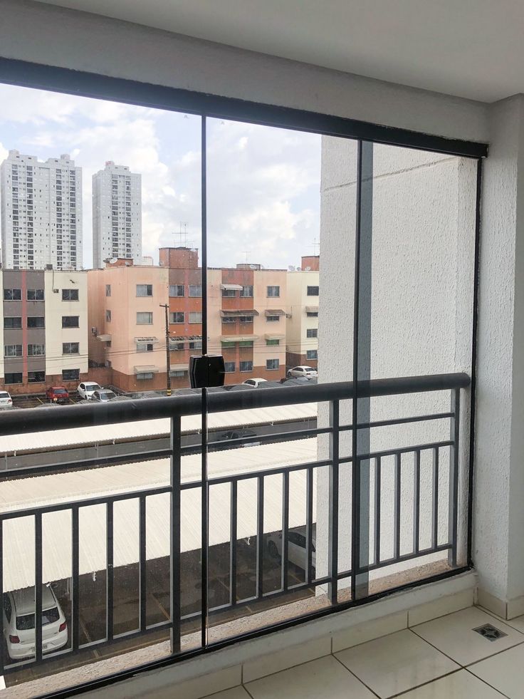 an empty balcony with cars parked in the distance