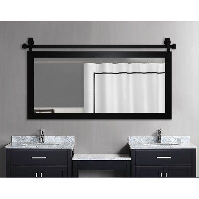 a bathroom vanity with two sinks and a large mirror above it, in front of a gray wall