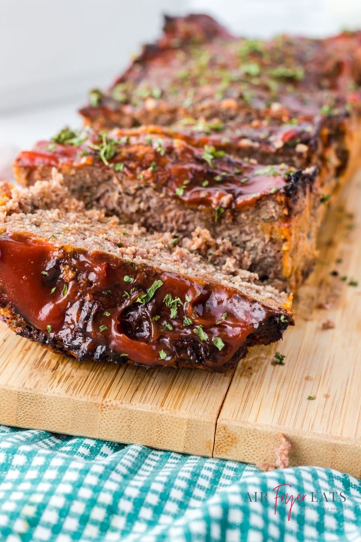 meatloaf with sauce and herbs on a cutting board