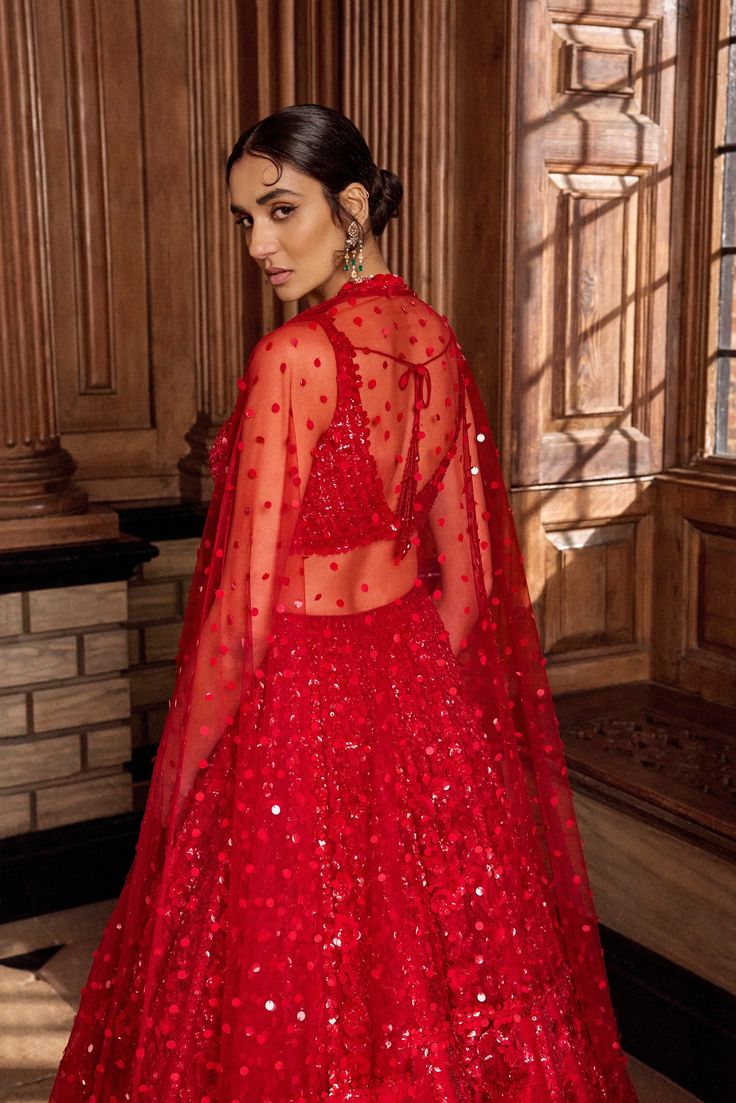 This red lehenga set features all over tonal sequin embroidery in a floral pattern. The ensemble is paired with a strappy blouse with tassels at the waist and a matching net dupatta.From Seema Gujral's A Royal Affair collection. DELIVERY TIMEPlease allow 8-12 weeks for your outfit to arrive. FABRIC DETAILSNet Professional cleaning only. Red Party Dress With Unstitched Blouse, Festive Red Sequined Anarkali Set, Red Sequined Sharara With Traditional Drape, Festive Red Choli For Evening, Glamorous Festive Net Lehenga, Festive Glamorous Net Lehenga, Glamorous Festive Lehenga In Net, Red Party Wear Lehenga With Dupatta, Red Evening Set With Sheer Dupatta