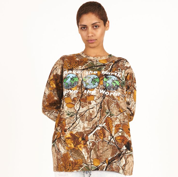 Looking for a stylish and eco-conscious addition to your wardrobe? Check out our Women’s Save the Earth Camo Long Sleeve Tee! Made from 100% heavyweight cotton, this tee features an allover camouflage print and a graphic on the front that reads "save the earth love the world" with earths. We've used a custom wash process to give the tee a soft hand feel, making it comfortable to wear all day long. With its unique design and eco-friendly message, this tee is the perfect choice for anyone who want