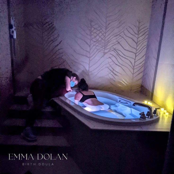 a woman sitting in a bathtub with the lights on