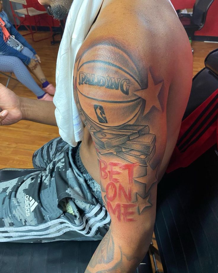 a man with a basketball tattoo on his arm and chest sitting in a gym chair