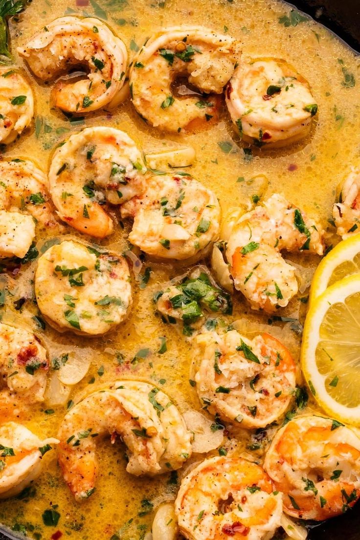 a skillet filled with shrimp and lemon slices