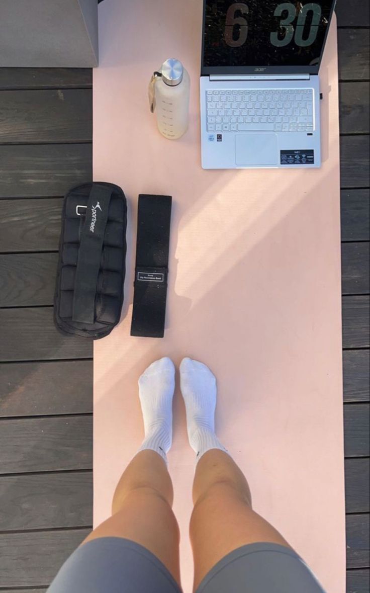 a woman's legs are shown next to a laptop and other items on a table