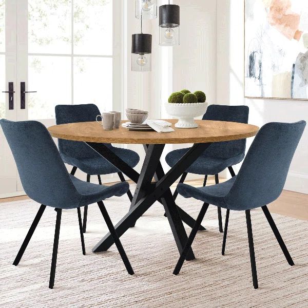 a dining table with four chairs and a bowl of fruit on it