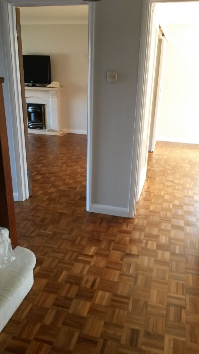 an empty living room with hard wood flooring