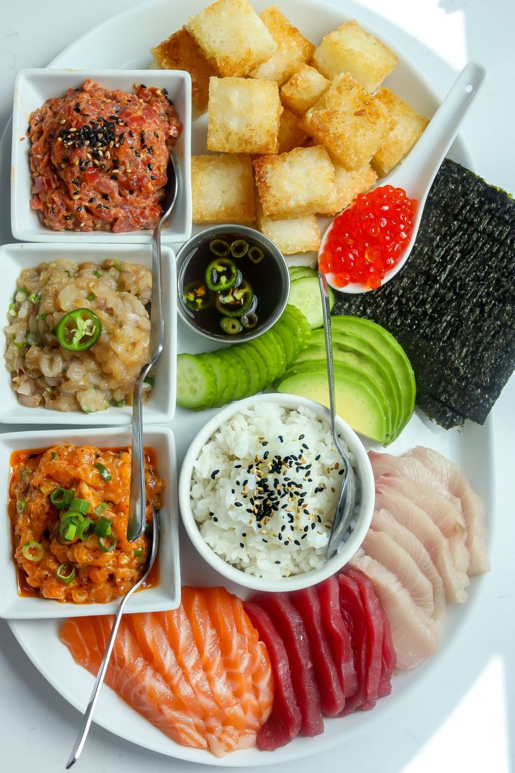 a white plate topped with different types of sushi and other foods on top of it