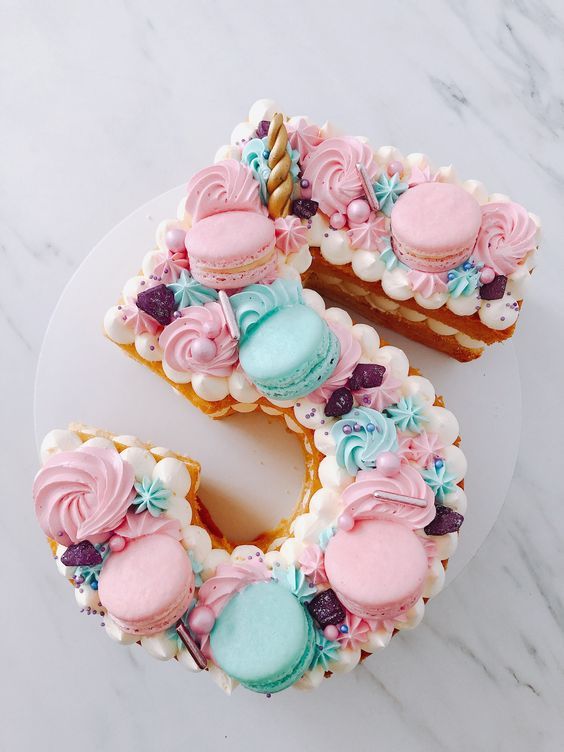 the letter e is made out of cookies and decorated with pink, blue, and white icing