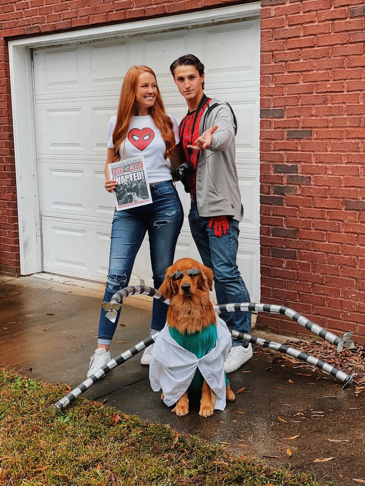 two people standing next to a dog in front of a garage