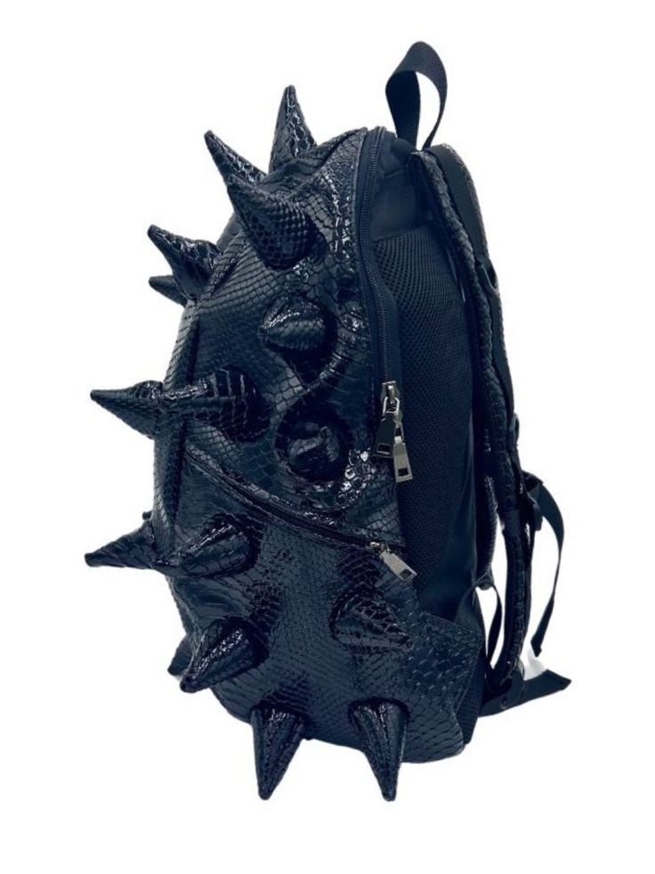 Black Out black backpack is your ticket to making an unforgettable statement. This black backpack's bold spike design and faux reptile texture commands attention and exudes confidence that sets you apart from the crowd. EXTERIOR Dimensions: 18" x 14" x 8" • Two zipper side pockets • Ergonomic mesh extra back padding • Adjustable Straps with chest strap for custom sizing • Heavy duty zippers with metal hardware • Top loop for hanging INTERIOR Padded laptop compartment protects electronics • Fits Tiny Bags, Reptile Skin, Chest Strap, Kickee Pants, Medium Backpack, Mini Melissa, Bag Clips, Metallic Bag, Large Backpack