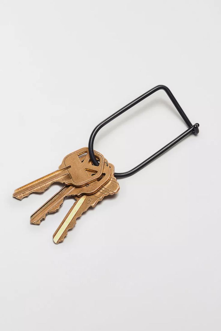 several keys attached to a black cord on a white surface