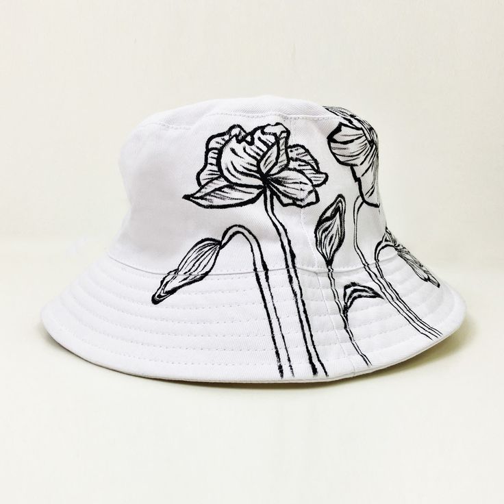 This is a unisex Hand-painted white bucket hat. Flowers are painted in fine black paint, perfect with a matching floral sweatshirt and shirt. It's perfect for festivals, sunny days out, and holidays! Machine Washable Custom White Bucket Hat, Bucket Hat Painting, White Bucket Hat, Floral Bucket Hat, Painted Clothes Diy, Bucket Hat White, Floral Sweatshirt, Paint Buckets, Painted Clothes