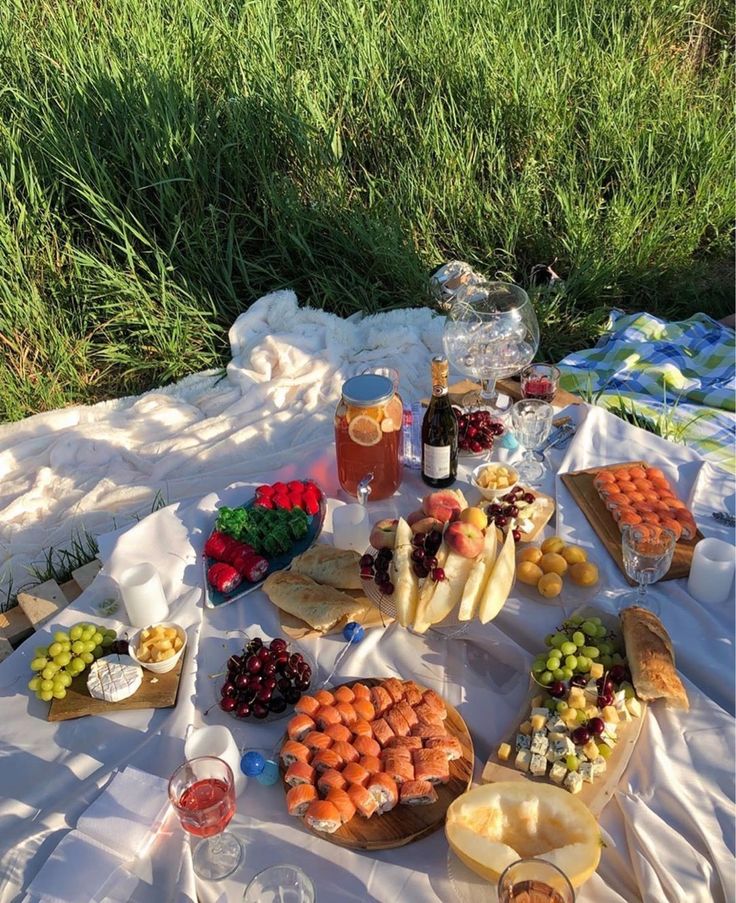 an outdoor picnic with food and drinks on the table