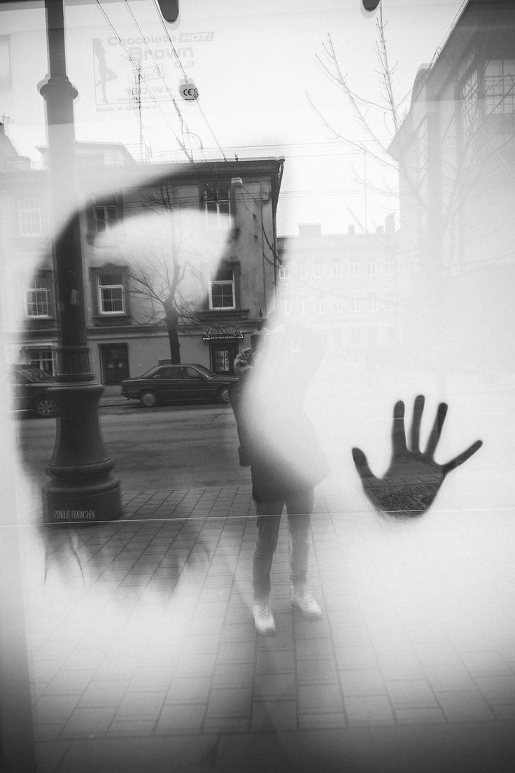 a person standing in front of a store window with their hand out to the side