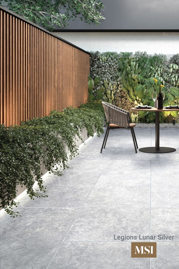 an outdoor dining area with table and chairs next to a wall covered in greenery