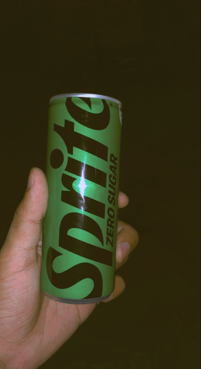 a hand holding a can of soda with the word smritic on it's side