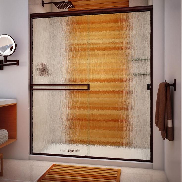 a bathroom with a walk in shower next to a white sink and wooden counter top