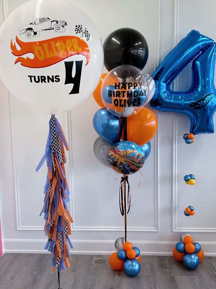 balloons and streamers in the shape of cars are on display at a birthday party