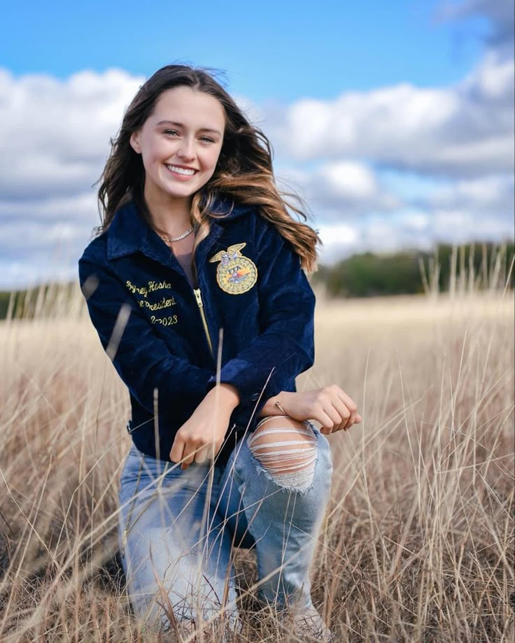 a young woman is posing in the tall grass