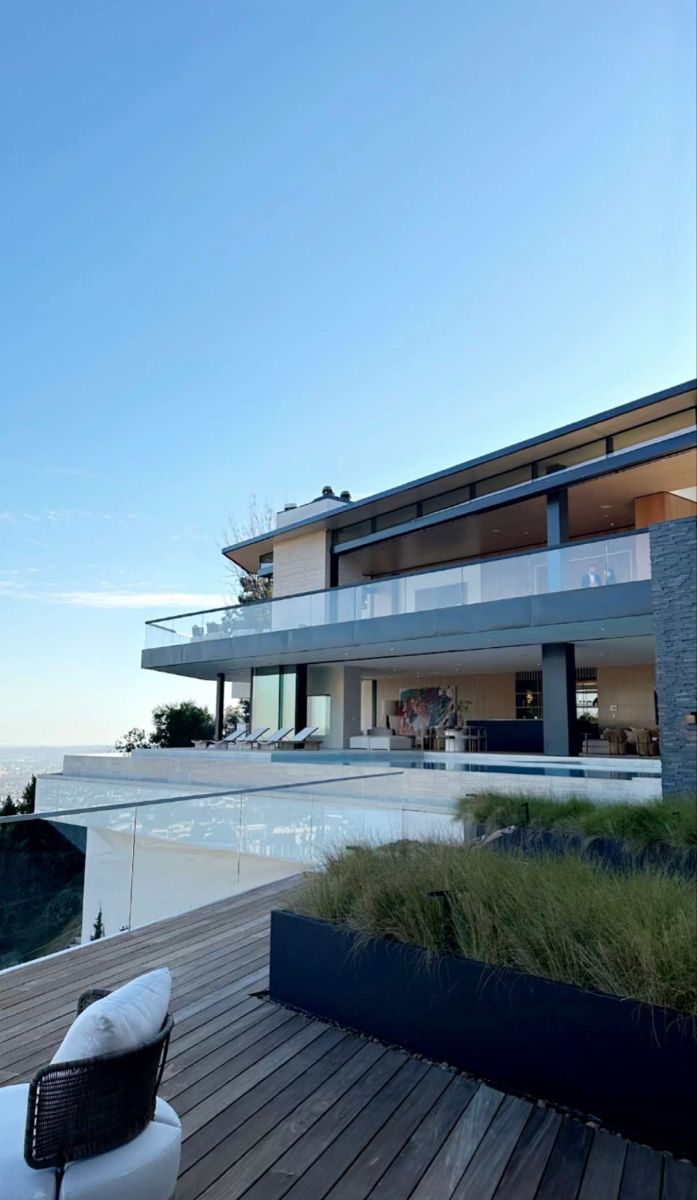 a modern house with an outdoor deck and planter