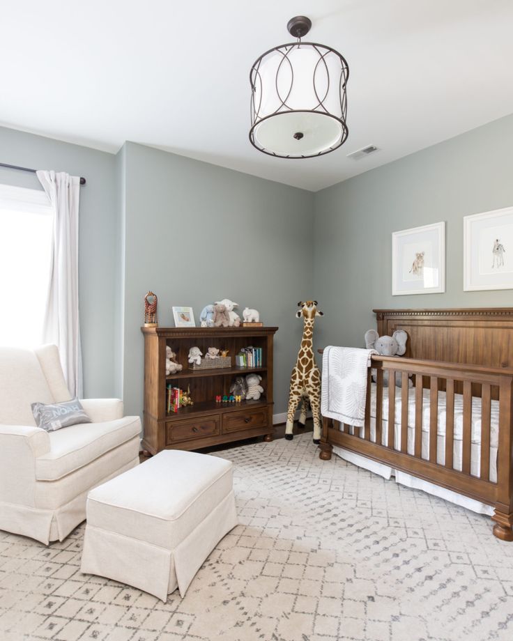 a baby's room with a crib, chair and dresser