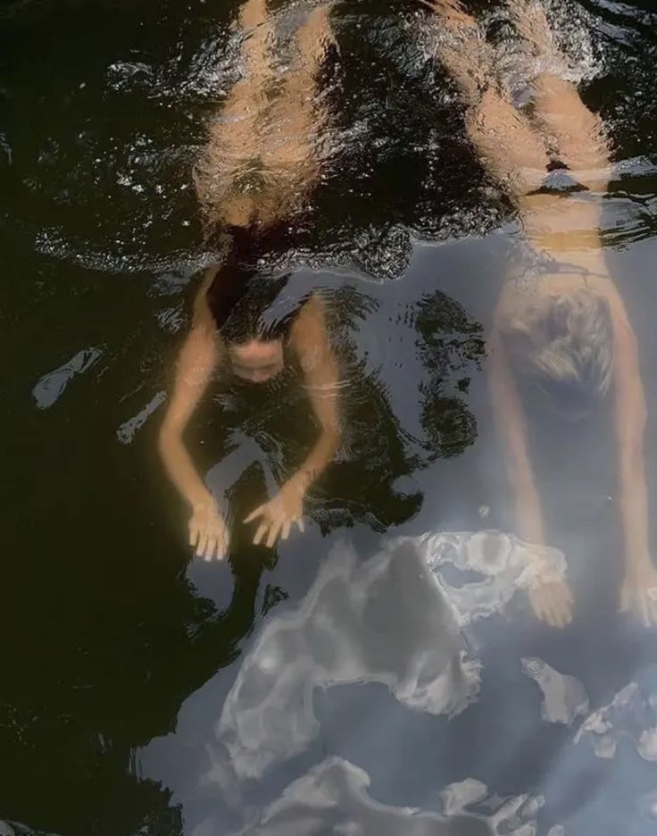 two people are swimming in the water together