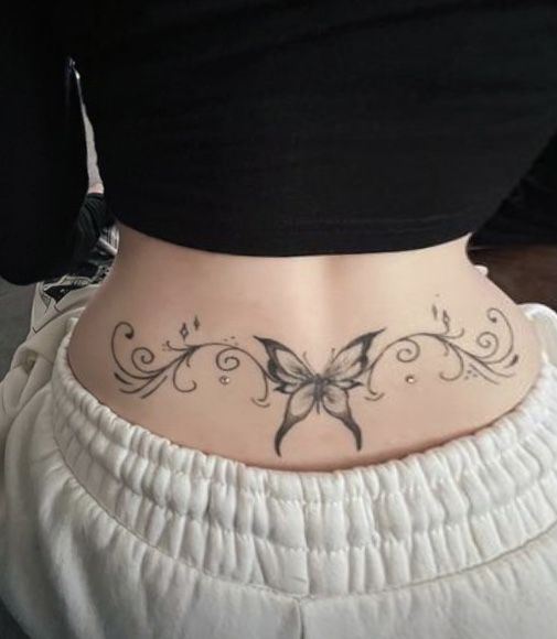 a woman with a butterfly tattoo on her lower back and the bottom part of her stomach