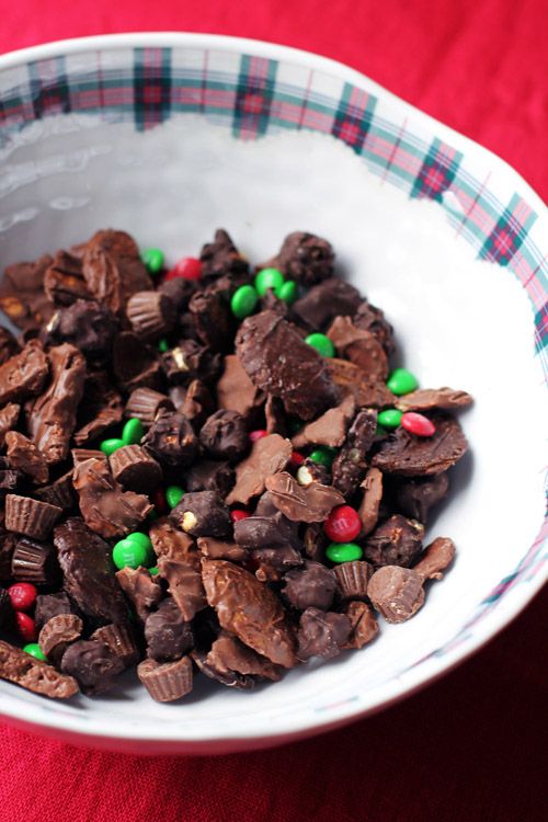 a white bowl filled with chocolate and green candy bits on top of a red table cloth