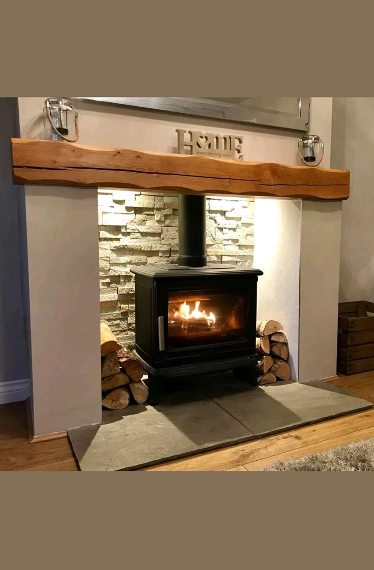 a wood burning stove sitting inside of a living room next to a pile of logs