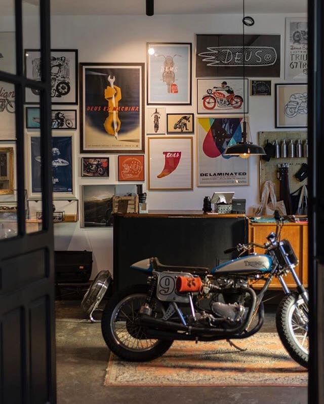 a motorcycle is parked in a garage with posters on the wall and below it are pictures