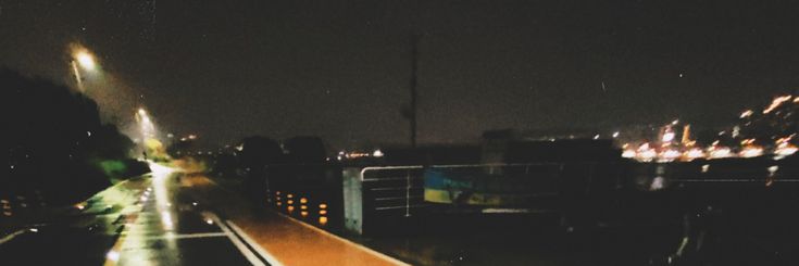 a city street at night with lights on and buildings in the background