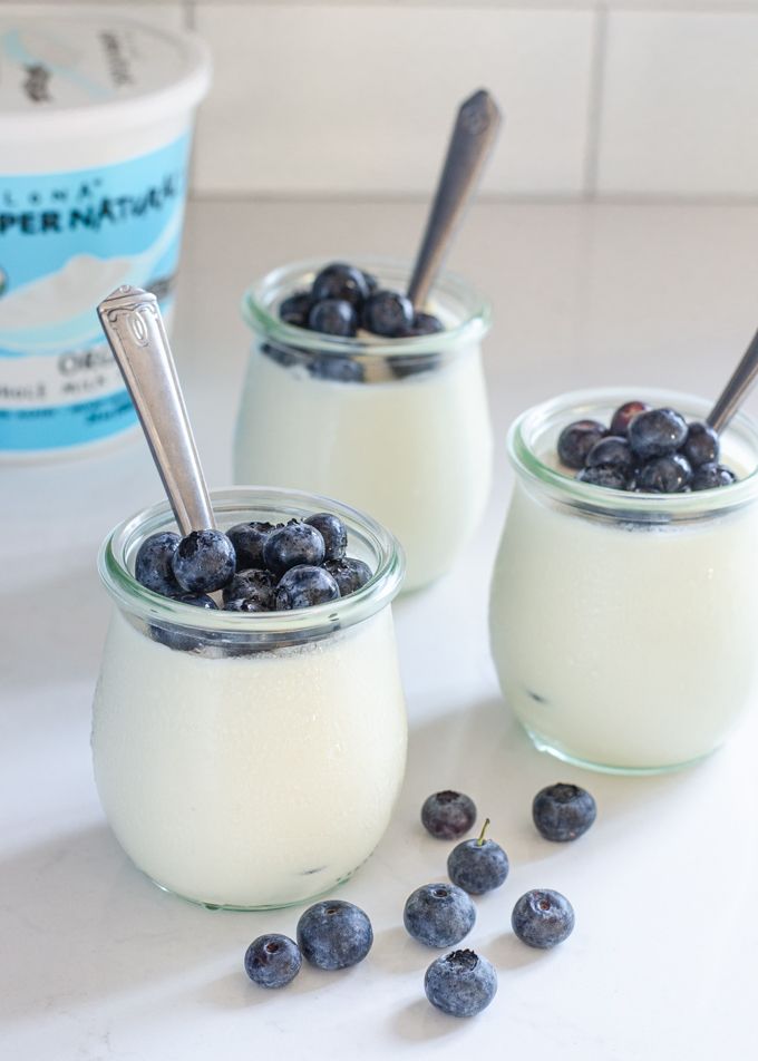 three small jars filled with blueberries and yogurt