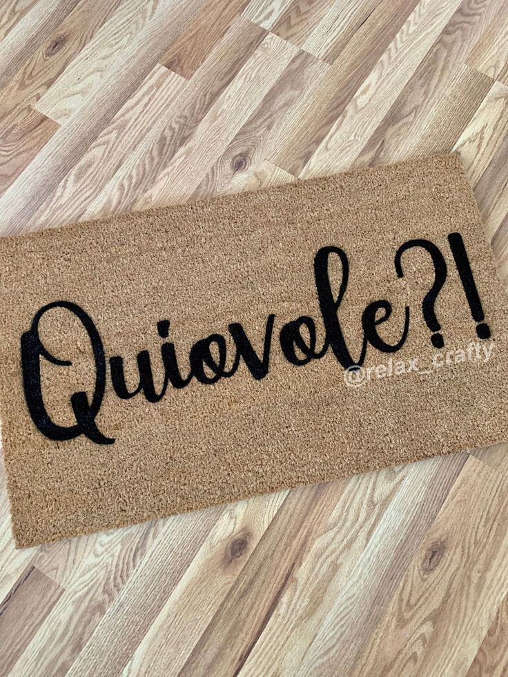 a welcome mat with the words quivole on it sitting on a wood floor