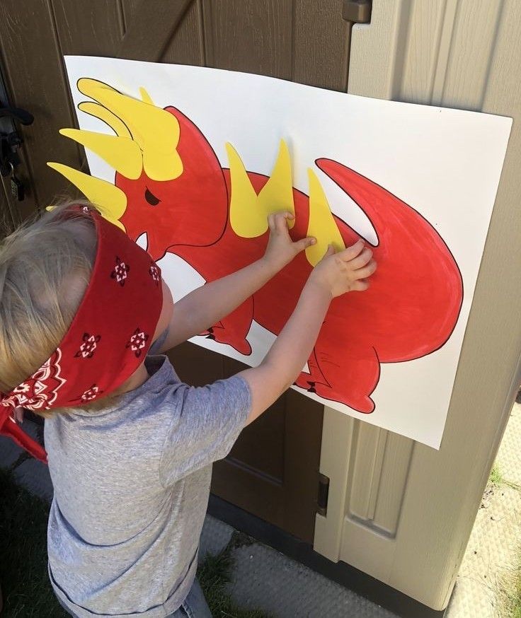 a young boy holding up a paper cut out of a lobster with yellow letters on it