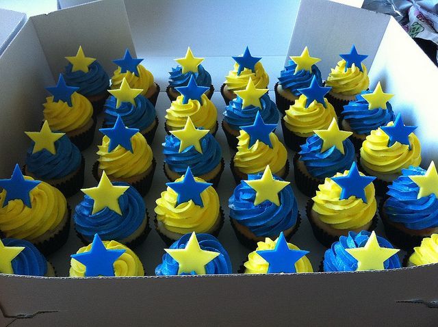 cupcakes with yellow and blue frosting in a box