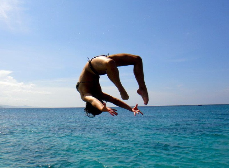 a woman diving into the ocean from a boat