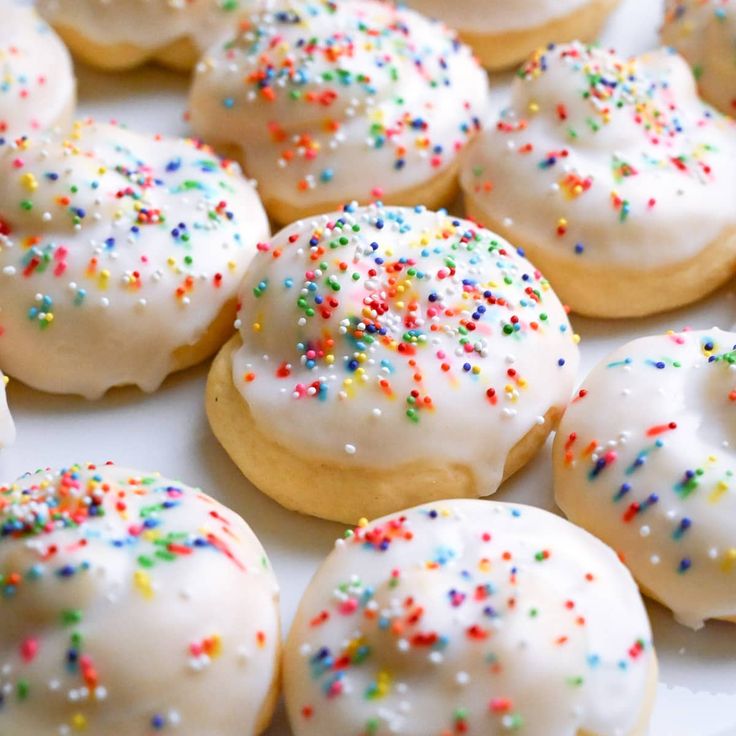 white frosted donuts with sprinkles on a plate